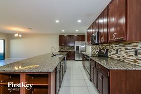 Palmetto house for rent - a large kitchen with granite counter tops and wooden cabinets