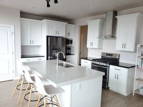 South Jordan house for rent - a white kitchen with stainless steel appliances and white cabinets