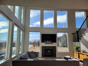 South Jordan house for rent - a living room with large windows and a couch and a television