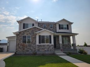 South Jordan house for rent - a stone house with a sidewalk in front of it