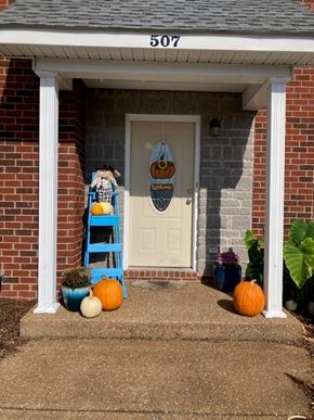 Smyrna apartment for rent - A house numbered 507 has a white door with a wreath and a small blue ladder with a pumpkin on it.