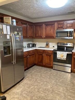 Smyrna apartment for rent - A kitchen with wooden cabinets and a stainless steel refrigerator.