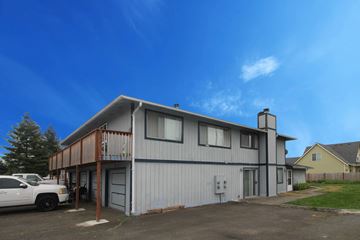 Enumclaw apartment for rent - a white building with a car parked in front of it