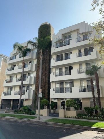 Los Angeles apartment for rent - a tall building with palm trees in front of it