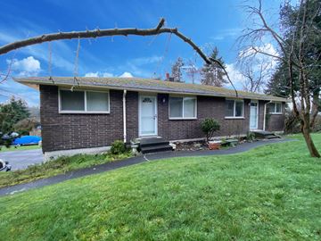 Federal Way apartment for rent - the front of a brick house with a tree branch in the foreground