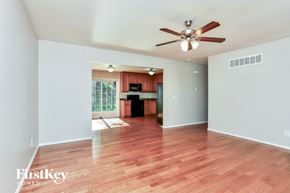 St Peters house for rent - an empty living room with wood flooring and a ceiling fan