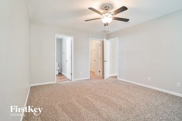 Greensboro house for rent - a spacious living room with carpet and a ceiling fan
