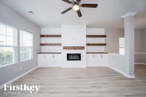 Moncks Corner house for rent - A spacious living room with a fireplace and wooden accents.