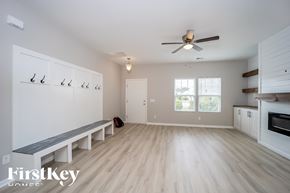 Moncks Corner house for rent - A spacious room with a bench and a ceiling fan.