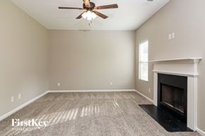 Dallas house for rent - a living room with a fireplace and a ceiling fan