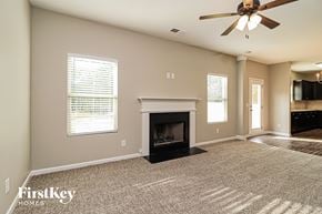 Dallas house for rent - a living room with a fireplace and a ceiling fan