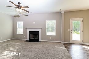 Dallas house for rent - a living room with a fireplace and a ceiling fan