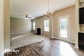 Dallas house for rent - an empty living room with a fireplace and a chandelier