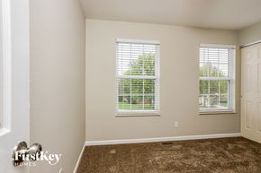St Charles house for rent - a bedroom with carpet and two windows and a door