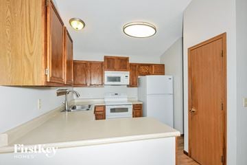 St Peters house for rent - a kitchen with white appliances and wooden cabinets