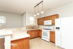 Rockledge house for rent - a kitchen with white appliances and wooden cabinets
