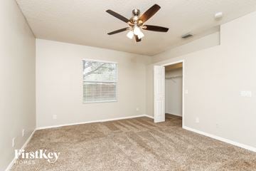 Rockledge house for rent - a spacious living room with carpet and a ceiling fan