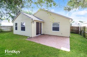 Rockledge house for rent - the backyard of a home with a brick patio and grass