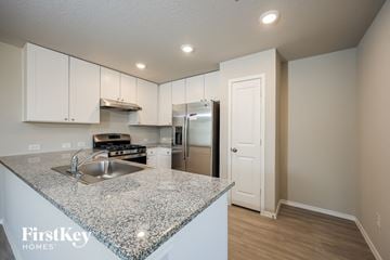 St Hedwig house for rent - a kitchen with white cabinets and a granite counter top