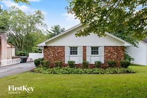 Greensboro house for rent - a white house with white shutters and a lawn and a tree