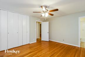 Greensboro house for rent - a bedroom with wood floors and a ceiling fan