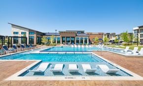 Georgetown apartment for rent - a swimming pool with lounge chairs and a building in the background