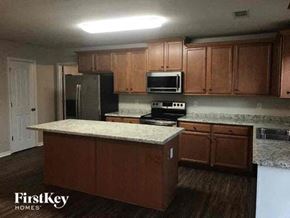 Charlotte house for rent - a kitchen with wooden cabinets and a counter top