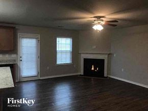 Charlotte house for rent - a living room with a fireplace and a ceiling fan