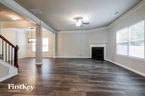 Winder house for rent - an empty living room with a fireplace and wooden floors
