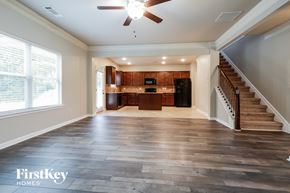 Winder house for rent - an empty living room with a staircase and a kitchen
