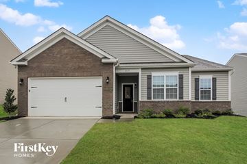 Charlotte house for rent - a brick house with a white garage door in front of a green lawn
