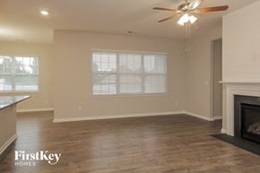 Charlotte house for rent - an empty living room with a fireplace and a ceiling fan