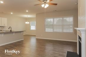 Charlotte house for rent - an empty living room and kitchen with a ceiling fan