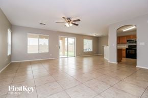Buckeye house for rent - an empty living room with tile flooring and a ceiling fan