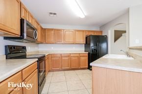 Buckeye house for rent - an empty kitchen with wooden cabinets and black appliances