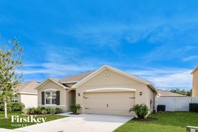 Zephyrhills house for rent - a beige house with a driveway and lawn
