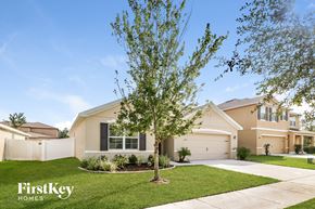 Zephyrhills house for rent - a beige house with a tree in front of it