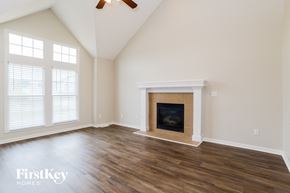 Kansas City house for rent - A room with a fireplace and a ceiling fan.