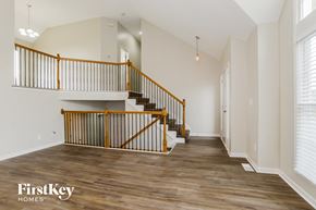 Kansas City house for rent - A wooden staircase with a metal railing in a spacious room.