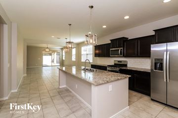 Tolleson house for rent - a large kitchen with granite counter tops and black cabinets