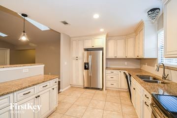 Jacksonville house for rent - A kitchen with a refrigerator, sink, and cabinets.