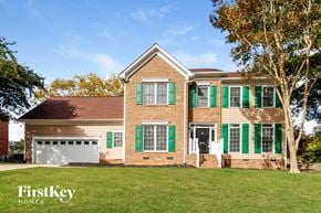 Greensboro house for rent - a brick house with green shutters and green garage doors