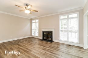 Greensboro house for rent - a living room with a fireplace and a ceiling fan