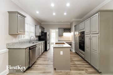 Greensboro house for rent - a kitchen with stainless steel appliances and granite counter tops