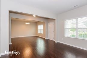 Charlotte house for rent - an empty living room with wood floors and a white door
