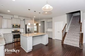 Charlotte house for rent - a white kitchen with a marble counter top and a staircase