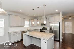 Charlotte house for rent - a kitchen with white cabinets and a marble counter top