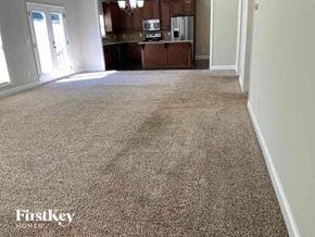 Clermont house for rent - an empty living room with a carpeted floor and a kitchen