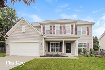 Mooresville house for rent - a beige house with pink shutters and a lawn