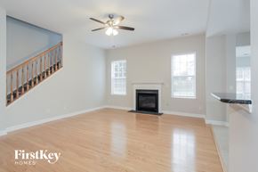 Mooresville house for rent - an empty living room with a fireplace and a ceiling fan